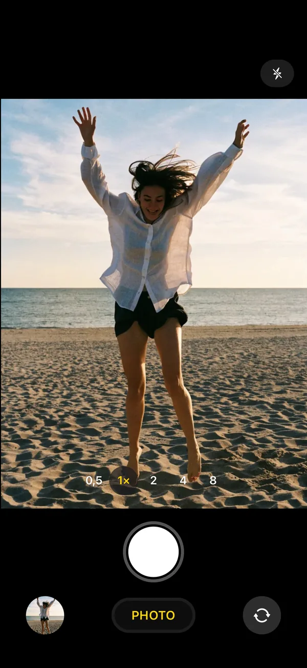 L’écran de prise de vue de Don’t Crop Me, pareil à l’appareil photo de l’iPhone : une personne saute sur la plage.